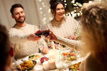 Image showing happy friends drinking red wine at christmas party