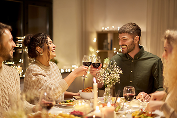 Image showing happy friends drinking red wine at christmas party