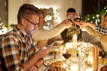 Image showing man with smartphone at dinner party with friends