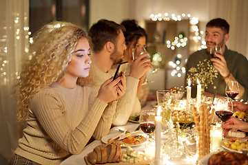 Image showing woman with smartphone at dinner party with friends