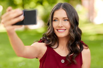 Image showing happy woman with smartphone taking selfie at park