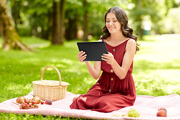 Image showing happy woman with tablet computer on picnic at park