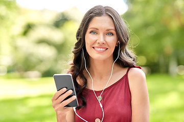 Image showing woman with smartphone and earphones at park