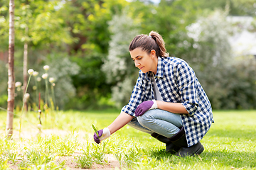 Image showing woman weeding flowerbed at summer garden