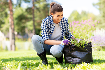 Image showing woman weeding flowerbed at summer garden