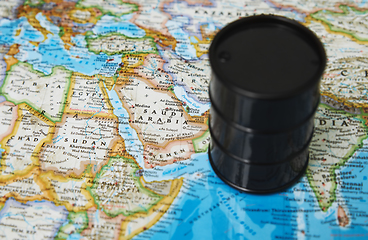 Image showing Oil drum with crude petroleum standing on a map