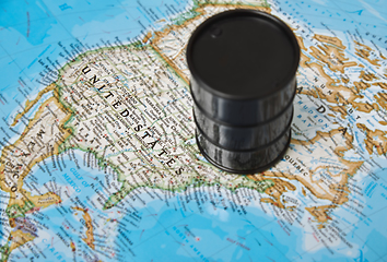 Image showing Oil drum with crude petroleum standing on a map