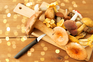 Image showing edible mushrooms on wooden cutting board and knife