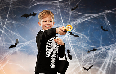 Image showing boy with candies and flashlight on halloween