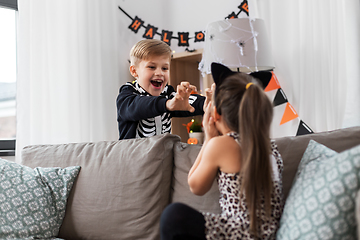 Image showing kids in halloween costumes playing at home