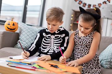 Image showing kids in halloween costumes doing crafts at home