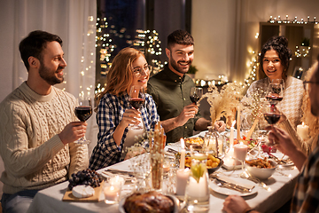 Image showing happy friends drinking red wine at christmas party