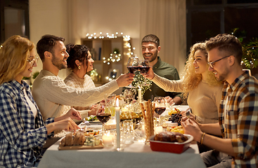 Image showing happy friends drinking red wine at christmas party