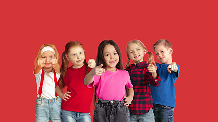 Image showing Portrait of little children gesturing isolated on red studio background with copyspace