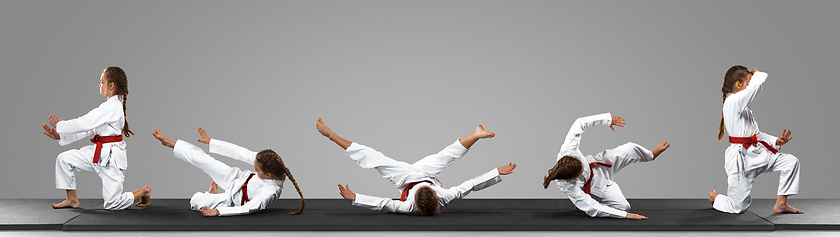 Image showing Young judo caucasian female fighter in white kimono with red belt in motion and action during training. Practicing martial arts fighting skills.