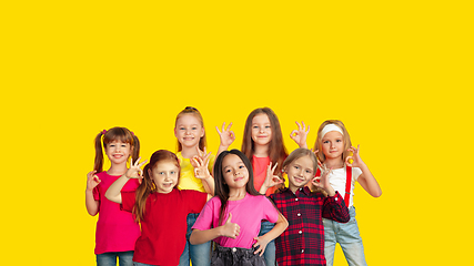 Image showing Portrait of little children gesturing isolated on yellow studio background with copyspace