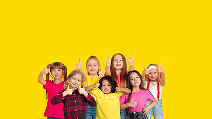 Image showing Portrait of little children gesturing isolated on yellow studio background with copyspace