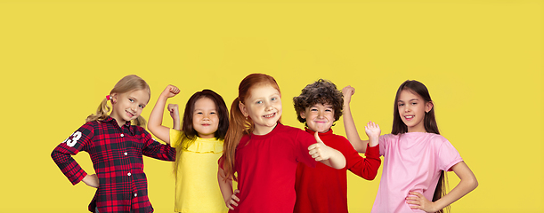 Image showing Portrait of little children gesturing isolated on yellow studio background with copyspace