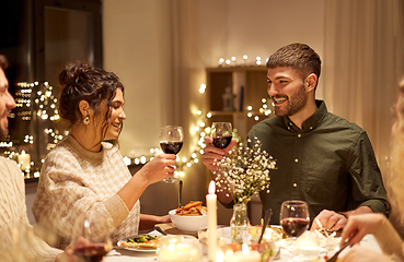 Image showing happy friends drinking red wine at christmas party