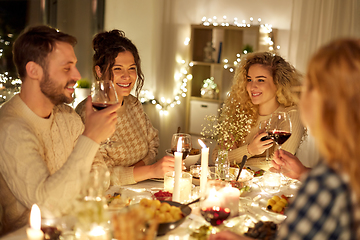 Image showing happy friends drinking red wine at christmas party