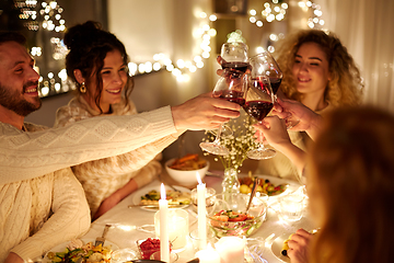 Image showing happy friends drinking red wine at christmas party