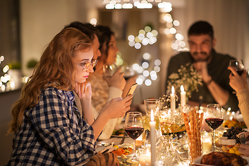 Image showing woman with smartphone at dinner party with friends