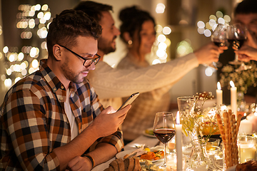 Image showing man with smartphone at dinner party with friends