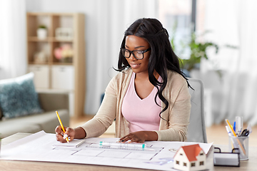 Image showing female architect with house model and blueprint