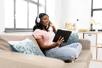 Image showing woman with tablet pc listening to music at home