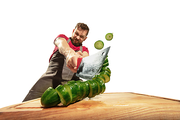 Image showing Amazing caucasian man preparing unbelievable food with action, details and bright emotions, professional cook isolated on white studio background.