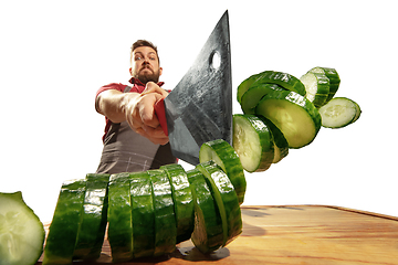 Image showing Amazing caucasian man preparing unbelievable food with action, details and bright emotions, professional cook isolated on white studio background.