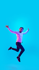 Image showing Caucasian man\'s portrait isolated on blue studio background in neon light. Concept of human emotions, facial expression, sales, ad.