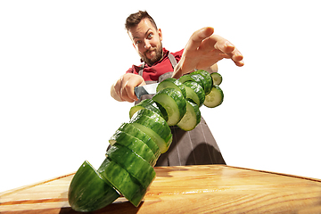 Image showing Amazing caucasian man preparing unbelievable food with action, details and bright emotions, professional cook isolated on white studio background.