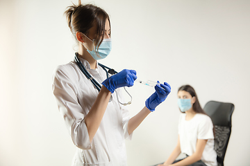 Image showing Doctor or nurse giving vaccine to patient using the syringe injected in hospital