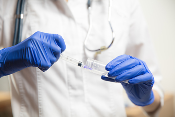 Image showing Doctor or nurse giving vaccine to patient using the syringe injected in hospital