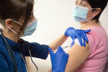 Image showing Close up doctor or nurse giving vaccine to patient using the syringe injected in hospital