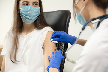 Image showing Close up doctor or nurse giving vaccine to patient using the syringe injected in hospital