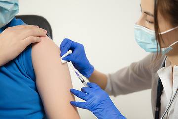 Image showing Close up doctor or nurse giving vaccine to patient using the syringe injected in hospital