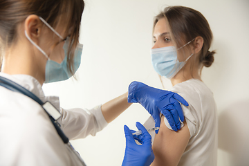 Image showing Close up doctor or nurse giving vaccine to patient using the syringe injected in hospital