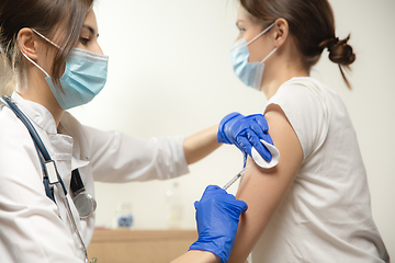 Image showing Close up doctor or nurse giving vaccine to patient using the syringe injected in hospital