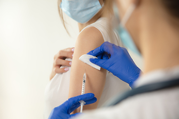 Image showing Close up doctor or nurse giving vaccine to patient using the syringe injected in hospital