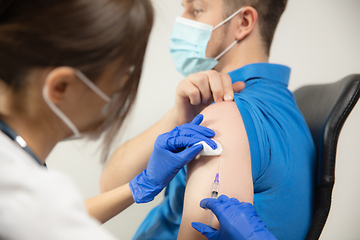 Image showing Close up doctor or nurse giving vaccine to patient using the syringe injected in hospital