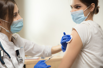 Image showing Close up doctor or nurse giving vaccine to patient using the syringe injected in hospital