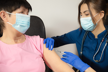 Image showing Close up doctor or nurse giving vaccine to patient using the syringe injected in hospital