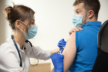 Image showing Close up doctor or nurse giving vaccine to patient using the syringe injected in hospital