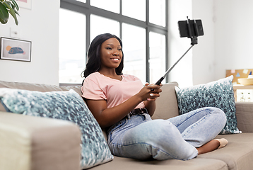 Image showing happy african american woman taking selfie at home