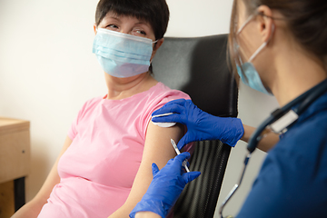 Image showing Close up doctor or nurse giving vaccine to patient using the syringe injected in hospital