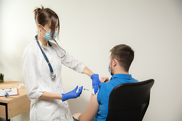 Image showing Close up doctor or nurse giving vaccine to patient using the syringe injected in hospital