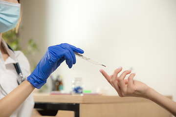 Image showing Doctor or nurse giving vaccine to patient using the syringe injected in hospital