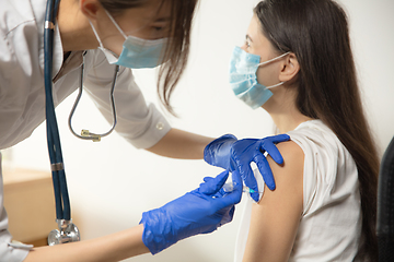 Image showing Close up doctor or nurse giving vaccine to patient using the syringe injected in hospital